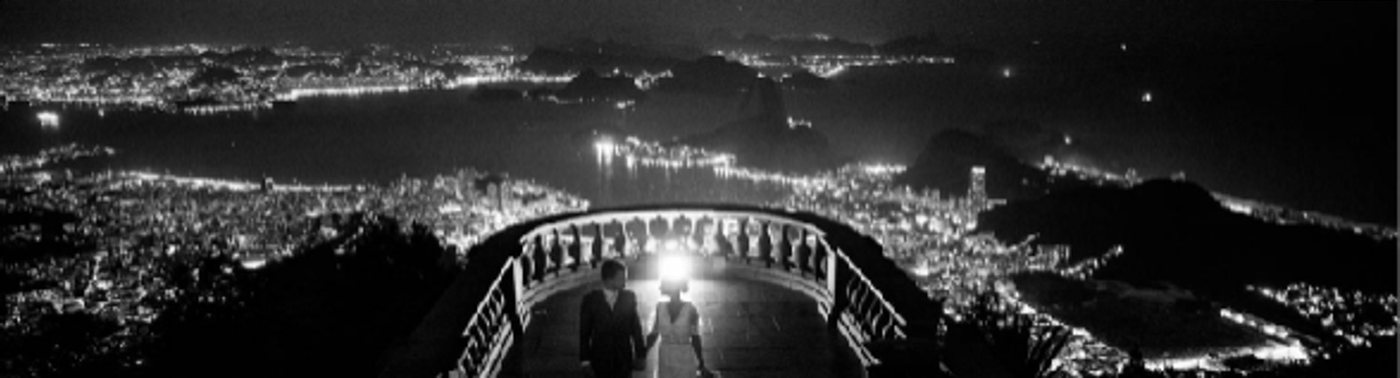 Casal no mirante à noite, cidade iluminada